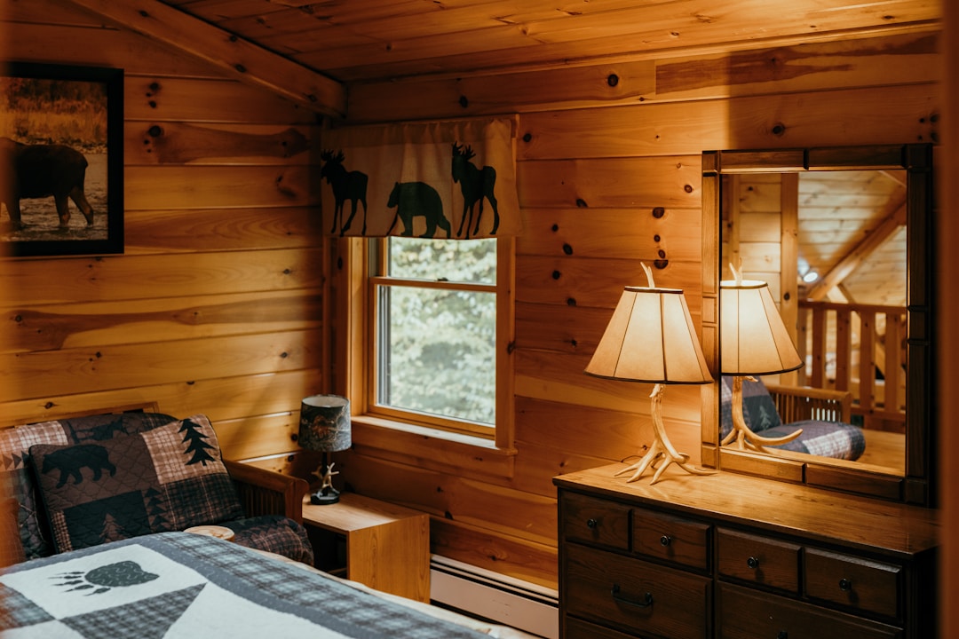 Cozy mountain cabin bedroom with handcrafted wood walls, wildlife decor, and rustic furniture