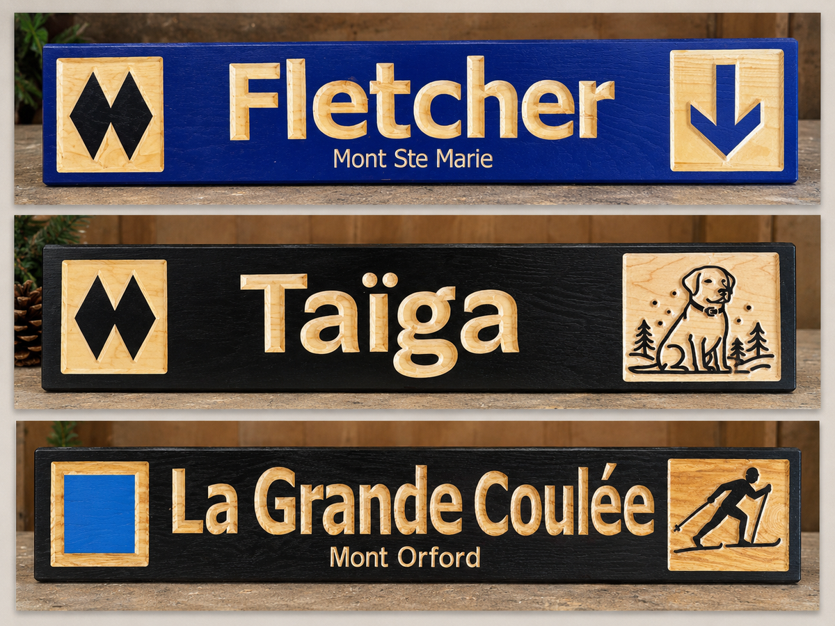 Three custom outdoor trail sign plaques displayed vertically on a wooden surface. The top plaque is blue with gold lettering reading 'Fletcher' and 'Mont Ste Marie', flanked by black-and-gold mountain symbols.