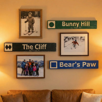 Personalized wooden ski trail signs and framed skiing photos on a cozy living room wall.