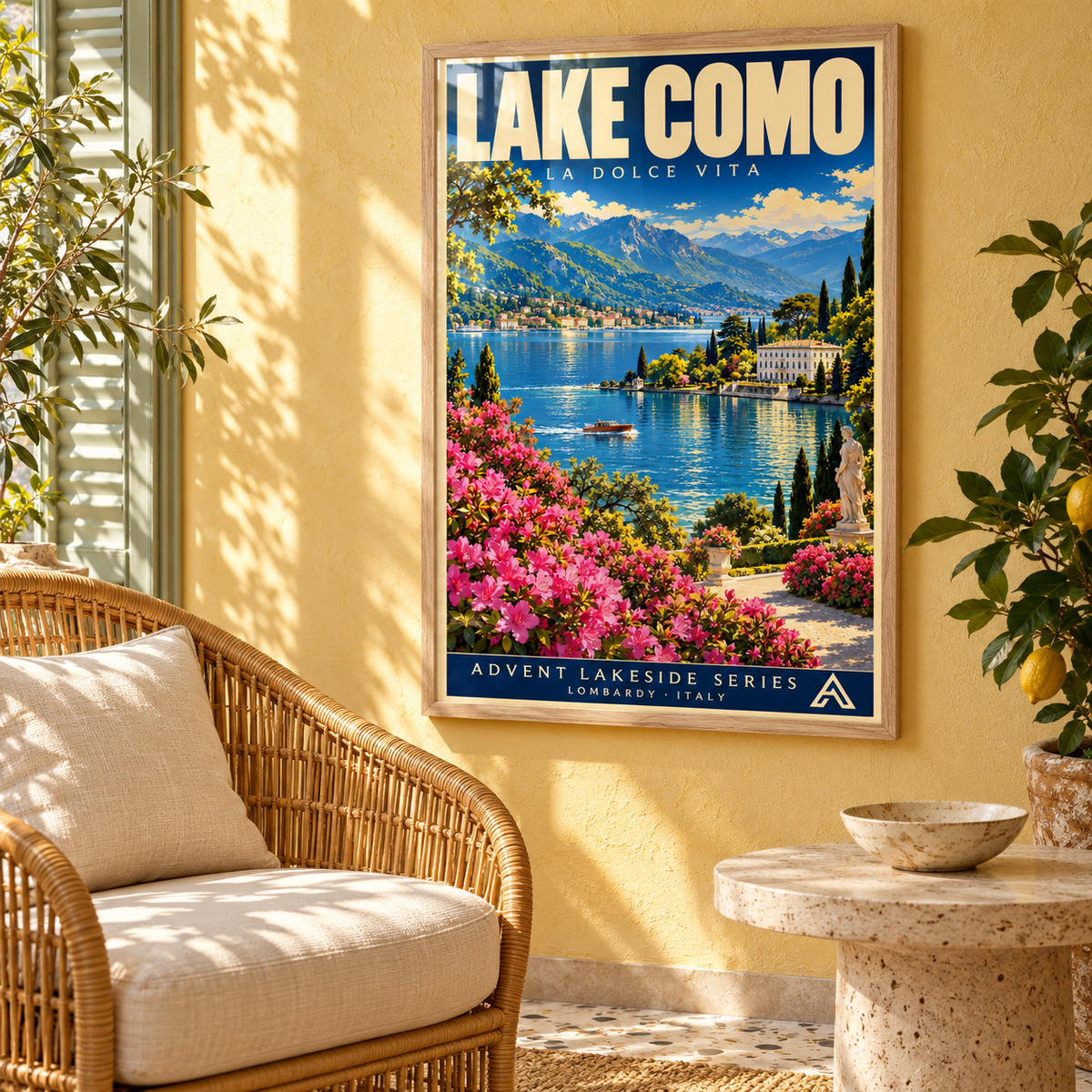 Lake Como framed art print in Natural Oak on a sunlit yellow plaster wall beside a rattan armchair and travertine table, with window reflections across the glazing.